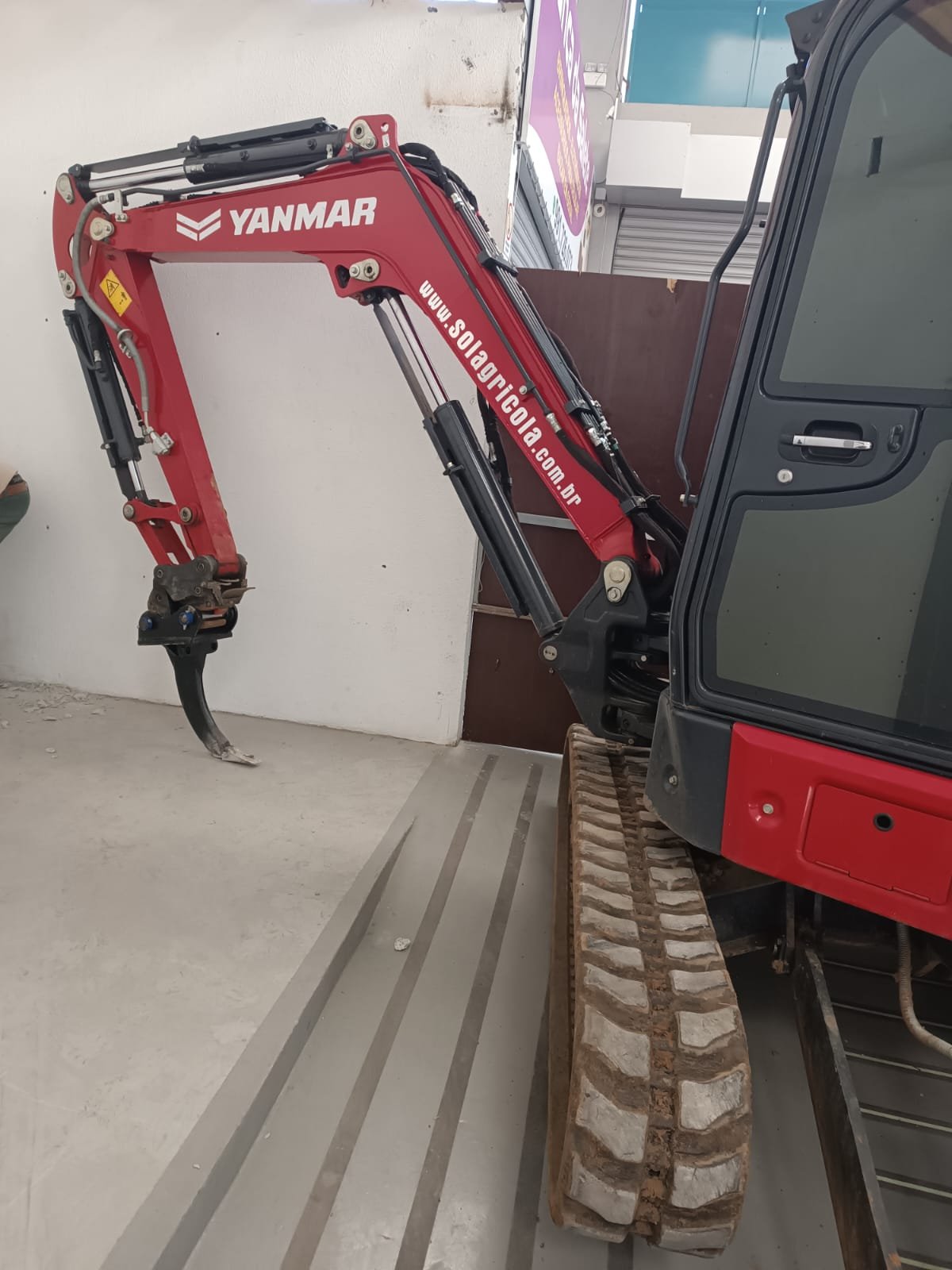 Mini escavadeira em operação em área restrita